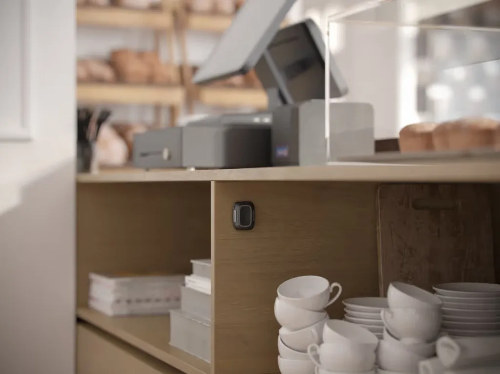 Ajax emergency button mounted discreetly at a counter, out of sight of the person opposite